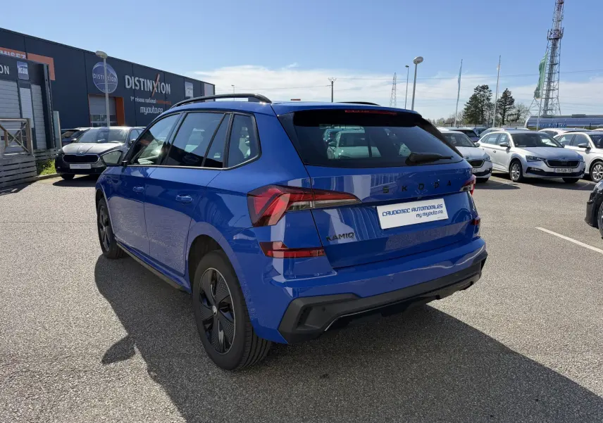 Vue 3/4 arrière droite d'un Skoda Kamiq bleu 2025 avec jantes alliage noires et feux arrière LED distinctifs.