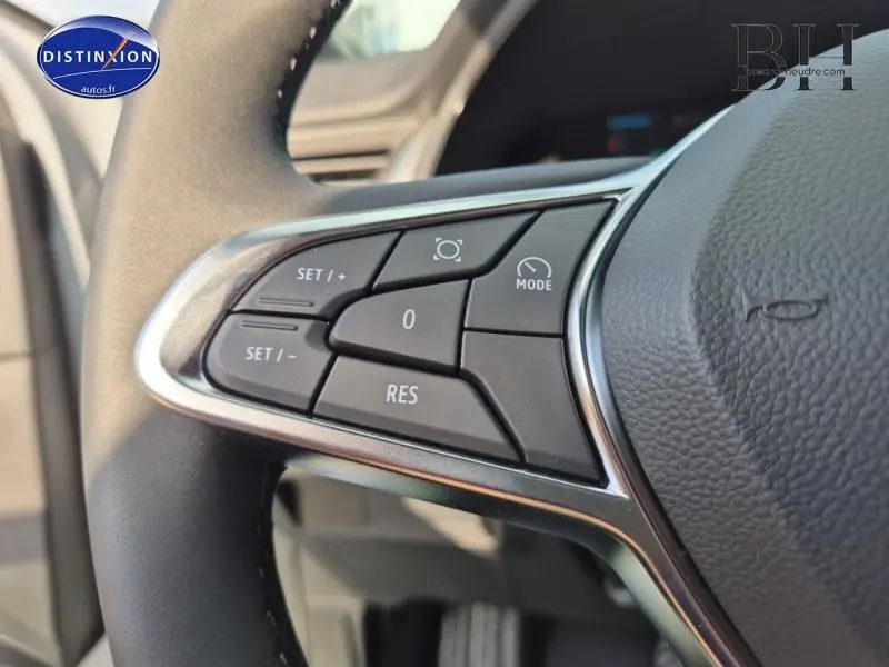 Gros plan sur les commandes multifonctions noires du volant cuir du Renault Captur gris Rafale 2025.