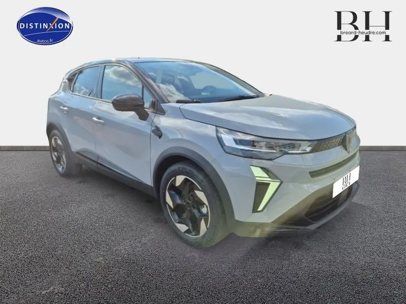 Renault Captur 2025 gris Rafale métallisé avec toit noir, vue 3/4 avant mettant en valeur ses feux LED distinctifs.