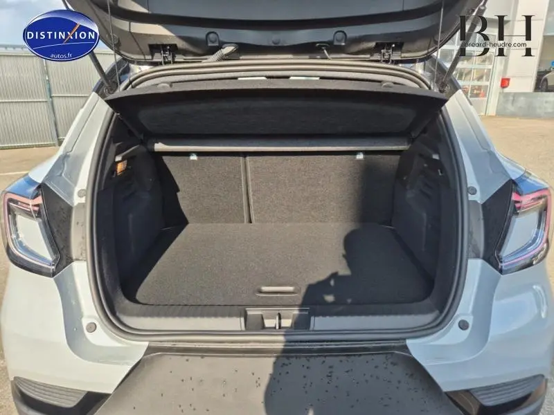 Coffre ouvert vu de l'arrière d'un Renault Captur 2025 gris Rafale métallisé avec feux arrière LED visibles.