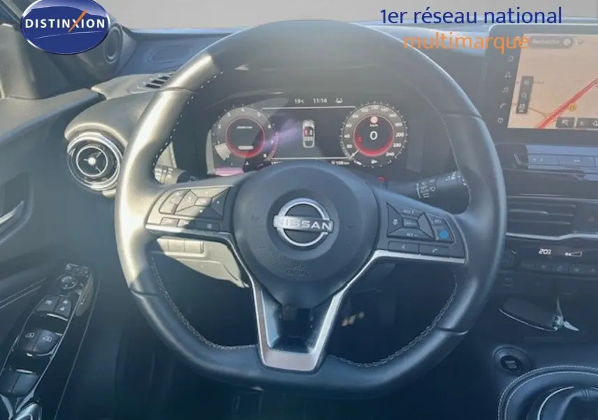 Vue rapprochée du volant cuir noir et tableau de bord numérique du Nissan Juke 2025, ambiance intérieure moderne.