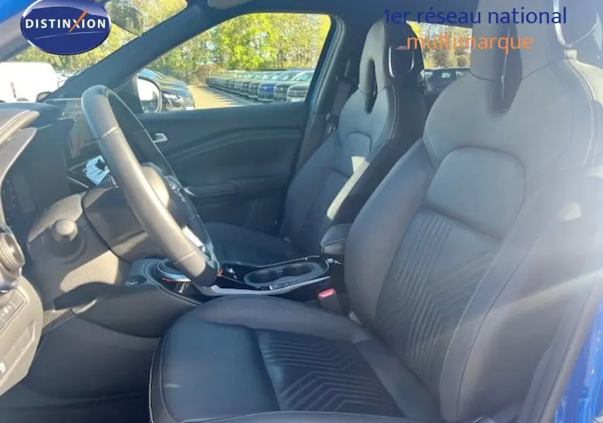 Vue intérieure côté conducteur du Nissan Juke 2025 bleu magnétique, sièges avant en cuir noir avec surpiqûres.