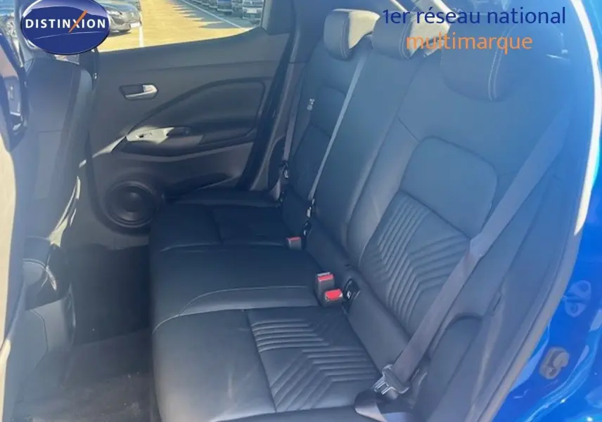 Vue intérieure arrière côté droit du Nissan Juke 2025 bleu magnétique, sièges en cuir noir avec ceinture de sécurité.