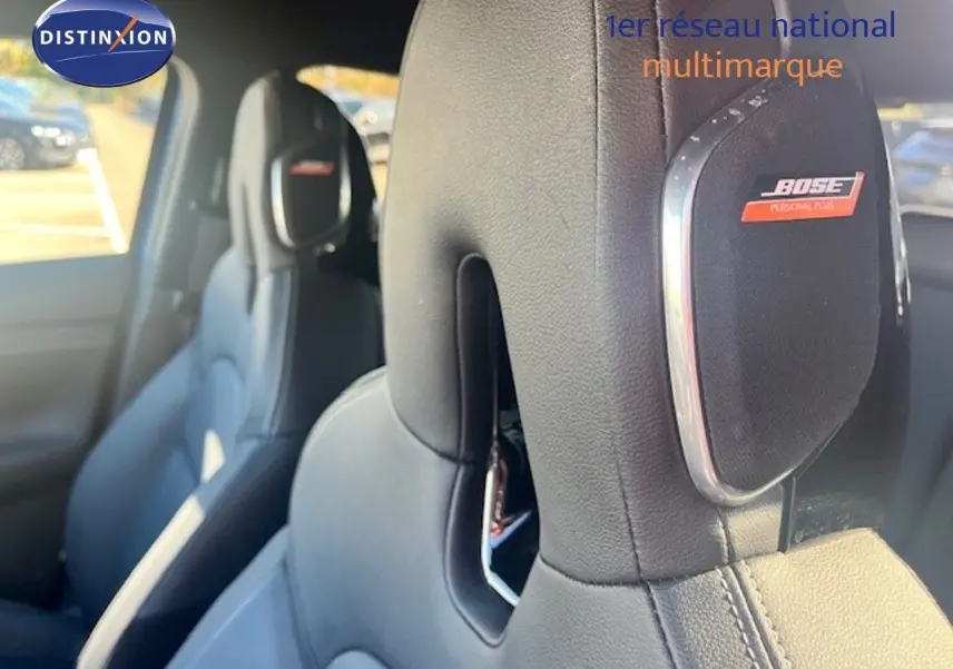 Gros plan sur les sièges avant en cuir noir du Nissan Juke 2025, avec haut-parleurs Bose intégrés aux appuie-têtes.
