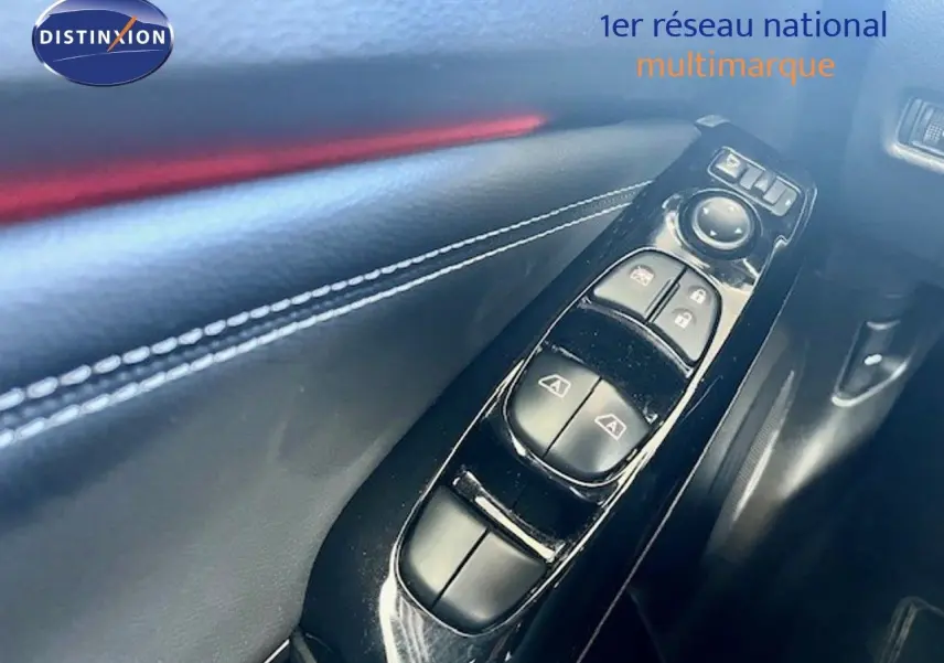 Gros plan sur les commandes de lève-vitres et verrouillage sur la portière intérieure noire du Nissan Juke 2025.
