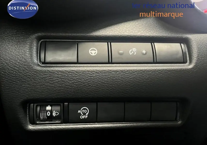 Gros plan sur les commandes de réglage d’éclairage et d’assistance au volant du Nissan Juke bleu magnétique.