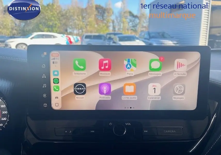 Écran tactile central du Nissan Juke 2025 bleu magnétique, affichant interface multimédia avec applications connectées.