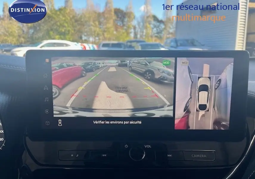 Vue intérieure sur l’écran multimédia affichant la caméra de recul et la vue 360° du Nissan Juke bleu magnétique métal.