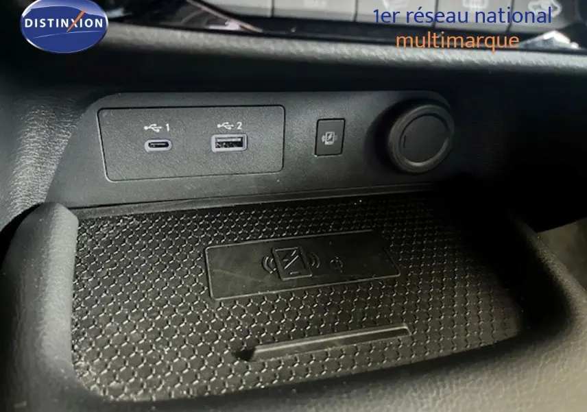 Gros plan sur la console centrale du Nissan Juke 2025, montrant les ports USB et la zone de charge sans fil.