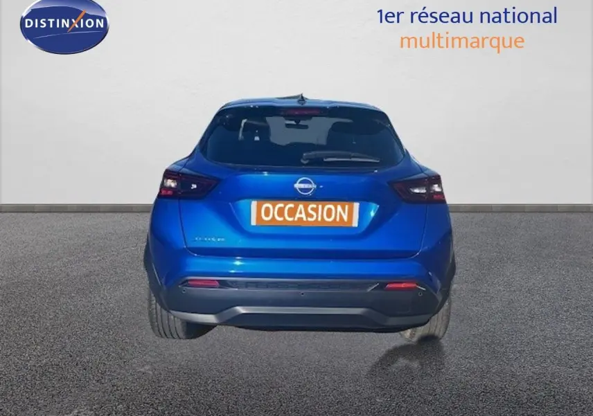 Vue arrière d'un Nissan Juke 2025 bleu magnétique métallisé avec feux arrière LED et plaque "OCCASION" visible.