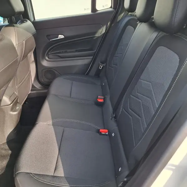 Vue intérieure côté droit des sièges arrière noirs du Jeep Avenger blanc 2025 avec ceinture et appuie-têtes visibles.