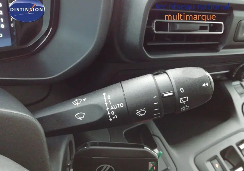 Gros plan sur la commande d’essuie-glace à gauche du volant dans l’habitacle sombre du Citroën Berlingo blanc 2026.