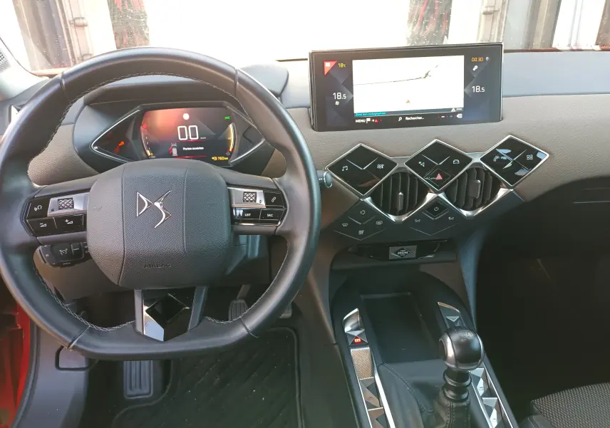Vue intérieure du tableau de bord et volant DS3 Crossback avec écran tactile et commandes modernes, volant cuir noir.