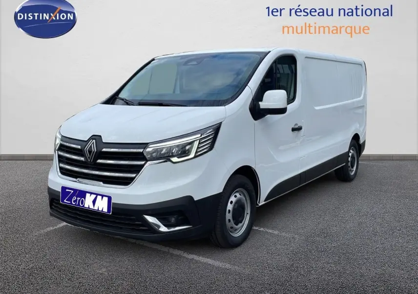 Renault Trafic Fourgon blanc glacier vu en 3/4 avant droit avec calandre noire et phares LED allumés.