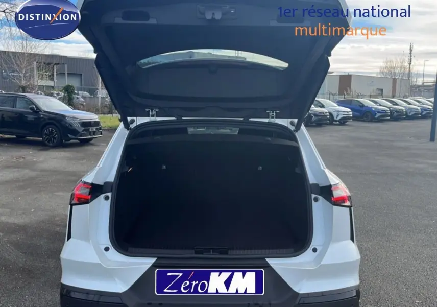 Vue arrière d'une Renault SYMBIOZ blanc nacré avec coffre ouvert, soulignant son espace de chargement généreux.