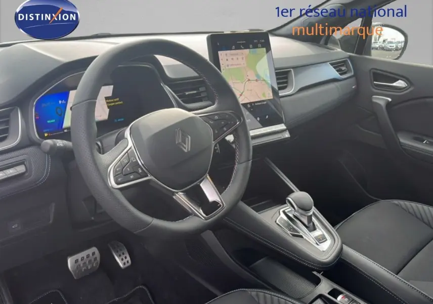 Vue intérieure de la Renault Symbioz 2025 en blanc nacré, montrant le volant, la console centrale et l'écran tactile vertical.