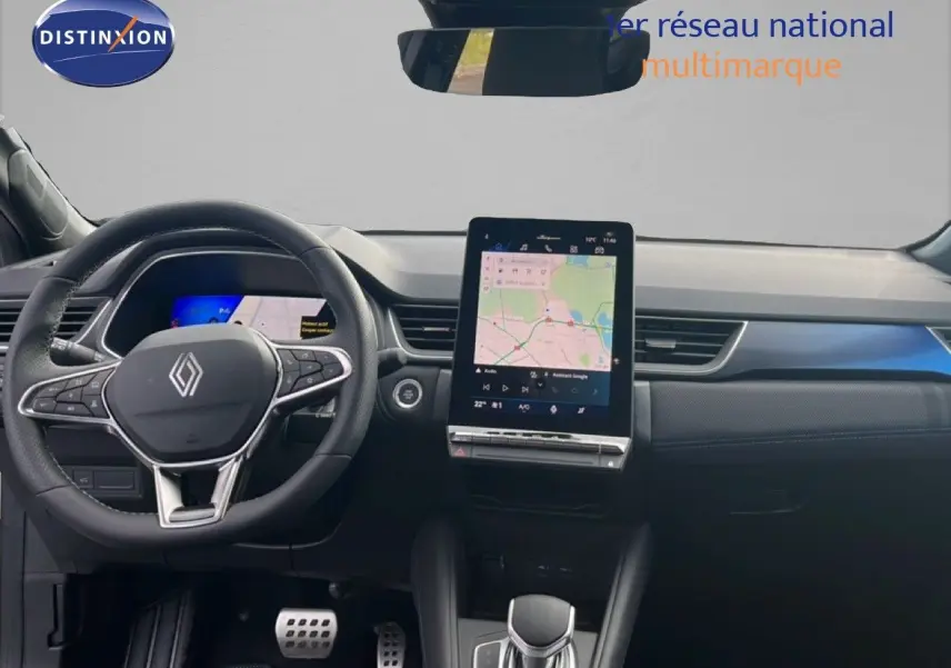 Vue intérieure frontale du tableau de bord de la Renault SYMBIOZ blanc nacré, avec écran tactile central et volant multifonction.