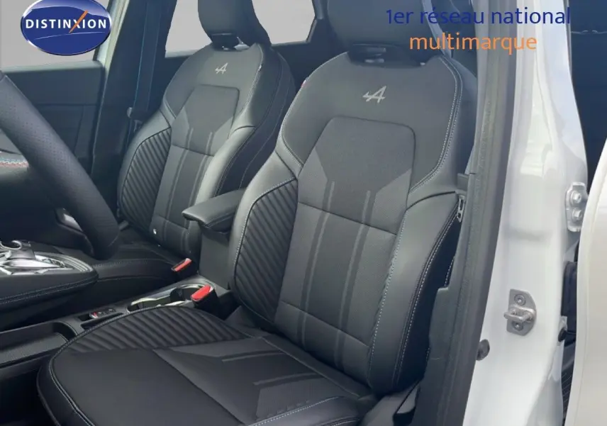 Vue intérieure côté conducteur du Renault Symbioz blanc nacré, sièges noirs avec logo Alpine brodé sur appuie-têtes.