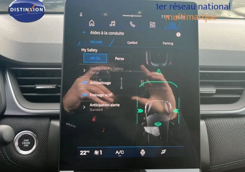 Vue intérieure centrée sur l'écran tactile du tableau de bord de la Renault Symbioz 2025 blanc nacré, affichant les aides à la conduite.