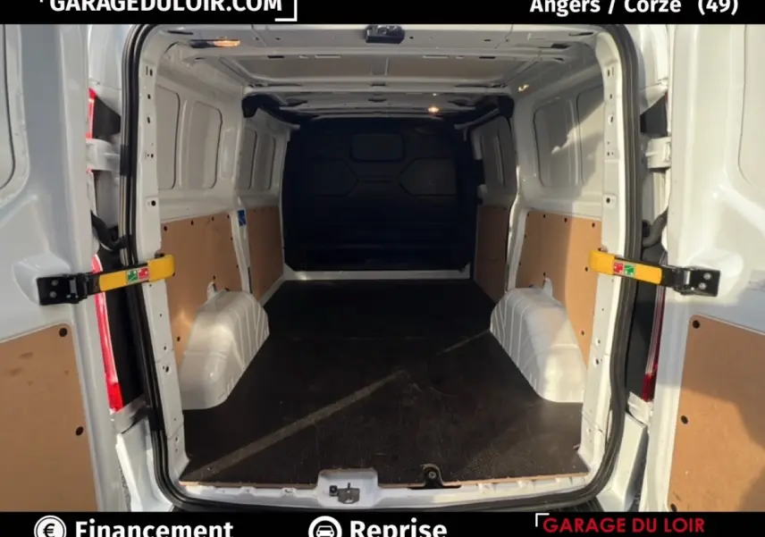 Vue arrière ouverte du fourgon blanc Ford Transit Custom 2023 montrant l'espace de chargement vide et protégé.