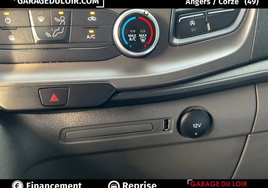 Détail de la console centrale du Ford Transit Custom blanc, montrant les commandes de climatisation et prise 12V.