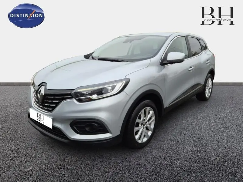 Renault Kadjar blanc en 3/4 avant droit, mettant en valeur sa calandre noire et ses jantes alu.