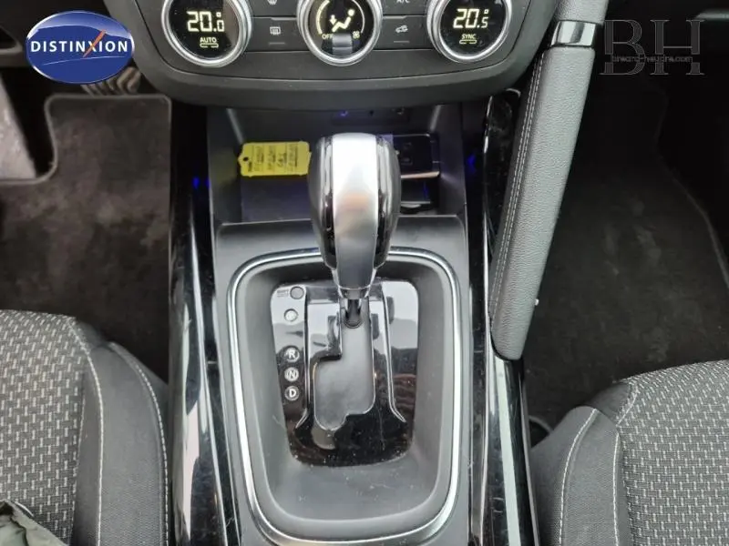 Vue rapprochée du levier de vitesses automatique noir et argenté du Renault Kadjar blanc, entouré de sièges tissu foncé.