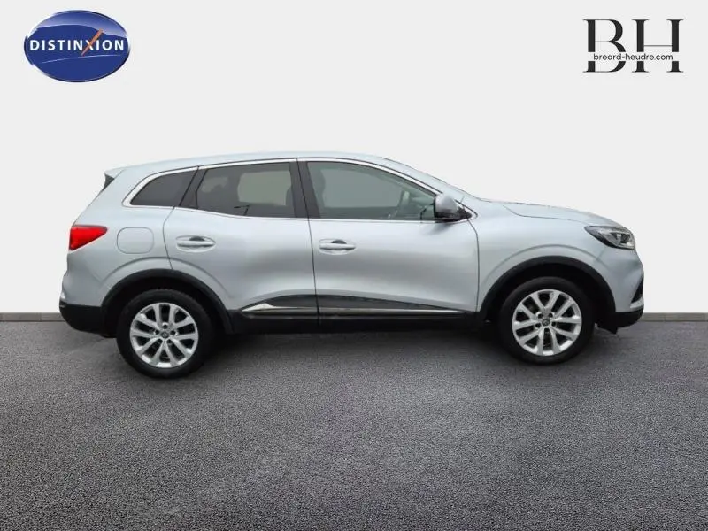 Profil droit du Renault Kadjar blanc Glacier 2022 avec jantes alu et vitres teintées sur fond neutre.