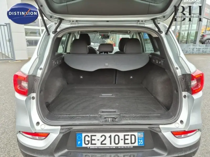 Coffre ouvert vu de l’arrière d’un Renault Kadjar blanc, montrant l’espace de chargement et la banquette arrière.