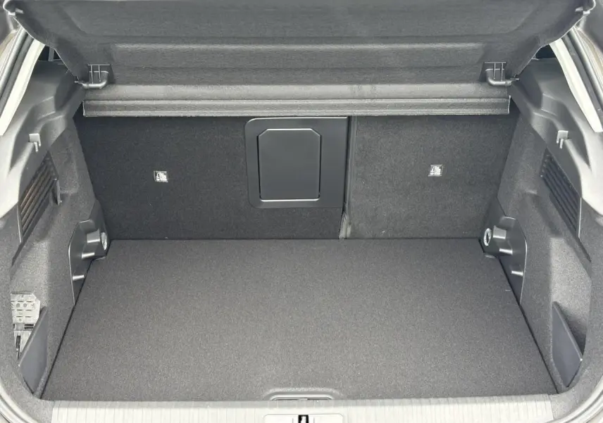 Coffre ouvert vu de l'arrière d'une Citroën C4 2024 gris Platinium, intérieur noir et espace de rangement spacieux.