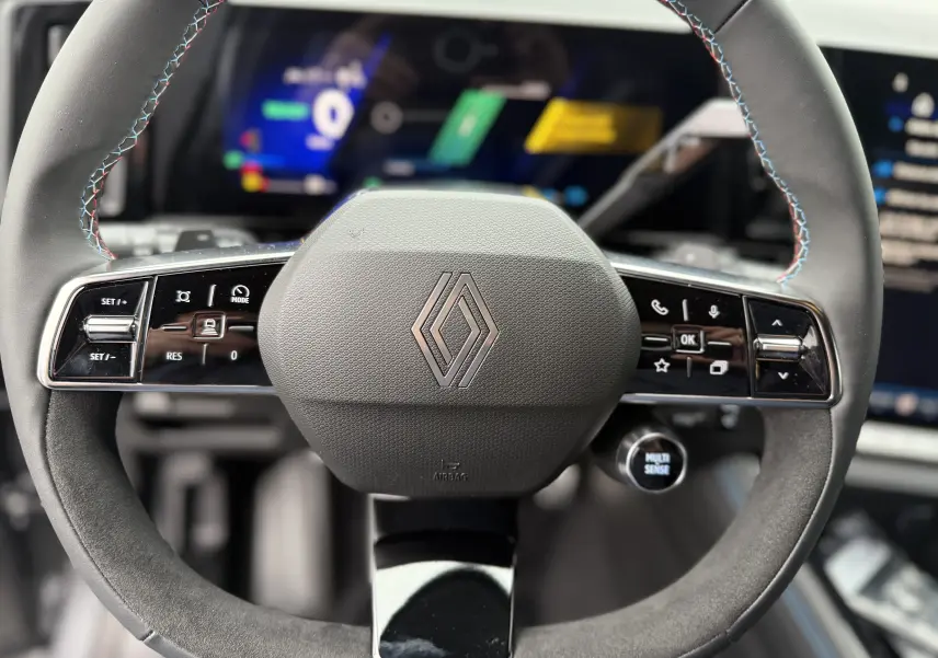 Gros plan sur le volant multifonction en cuir noir avec surpiqûres tricolores du Renault Austral 2025.