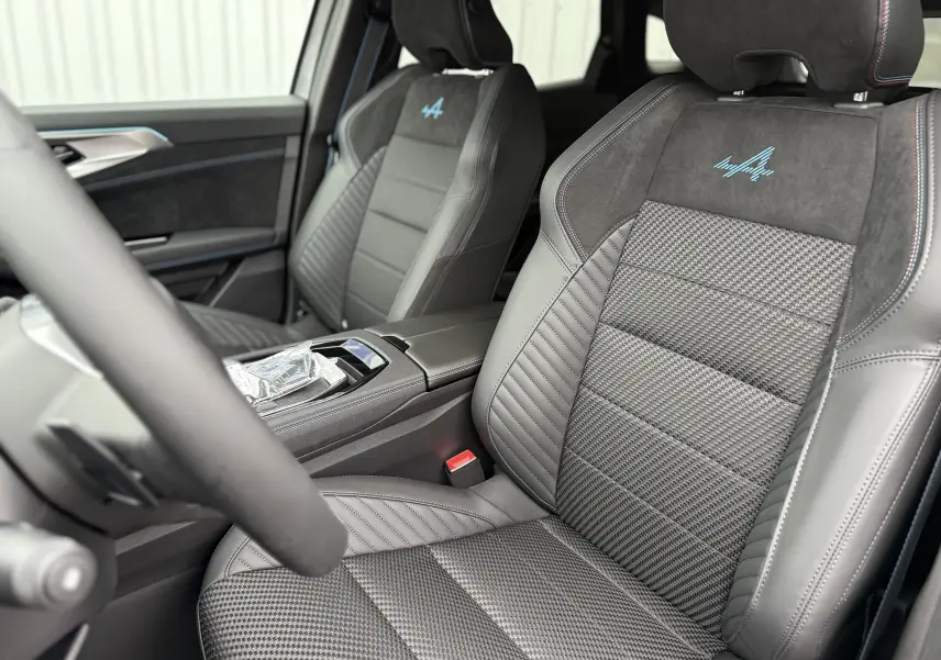 Vue intérieure rapprochée des sièges avant gris avec logo Alpine bleu sur une Renault Austral 2025 finition Esprit Alpine.