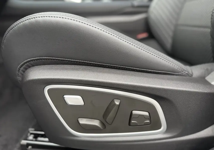 Gros plan sur les commandes électriques du siège avant en cuir noir du Renault Austral 2025 finition Esprit Alpine.
