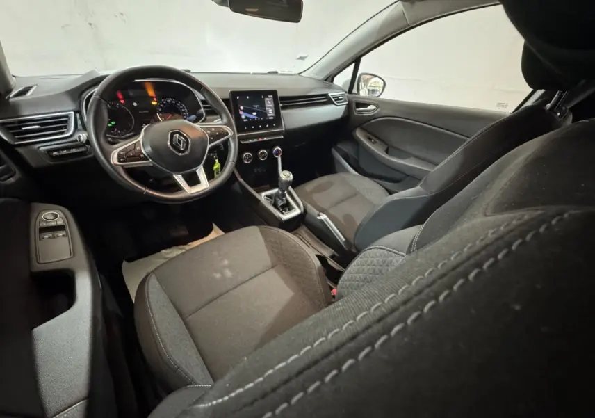 Vue intérieure avant droite de la Renault Clio Business 2020, montrant le volant cuir, écran tactile et sièges tissu noirs.