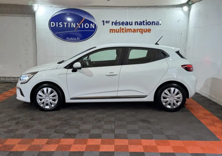 Profil droit d'une Renault Clio Business TCe 100 blanche de 2020, avec jantes acier et feux LED visibles en intérieur showroom.