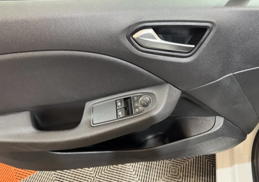 Vue rapprochée de la porte avant gauche noire de la Renault Clio Business TCe 100 blanche avec commandes électriques.