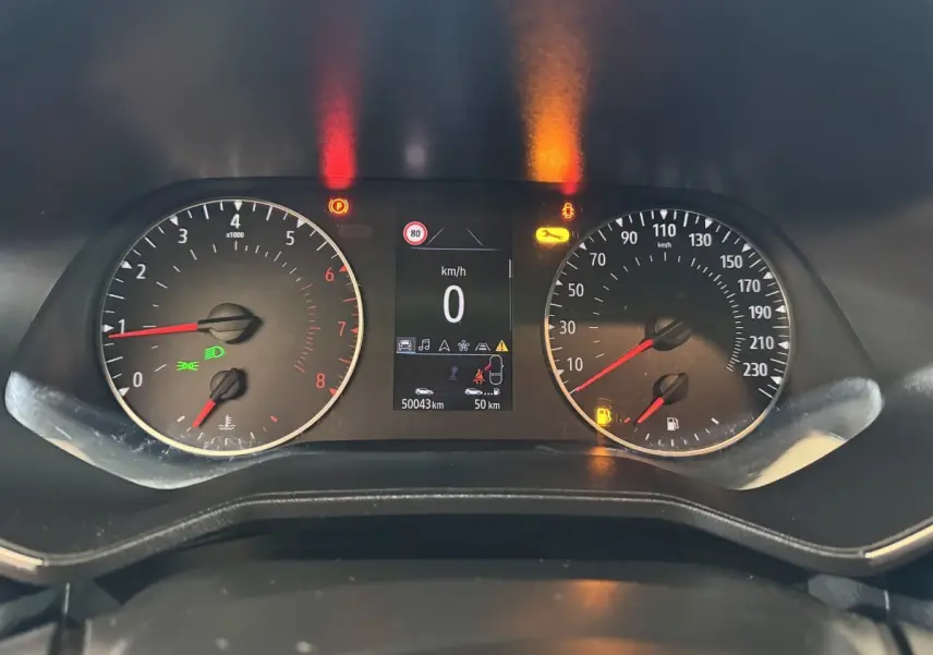 Vue rapprochée du tableau de bord de la Renault Clio Business blanc, affichage digital et compteurs analogiques allumés.