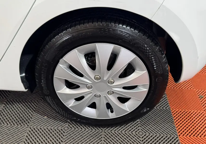 Gros plan sur la roue arrière droite d'une Renault Clio blanche, avec jante en alliage argenté et pneu Continental.