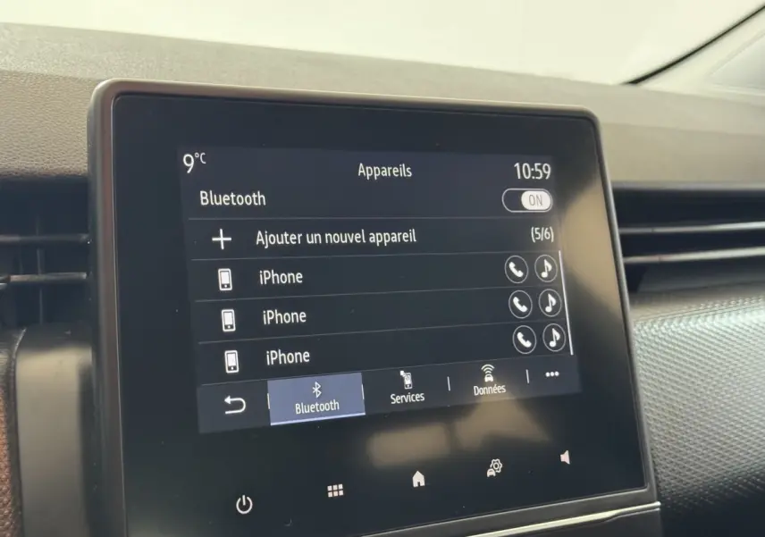 Écran tactile central de la Renault Clio Business blanc de 2020 affichant le menu Bluetooth avec plusieurs iPhone connectés.
