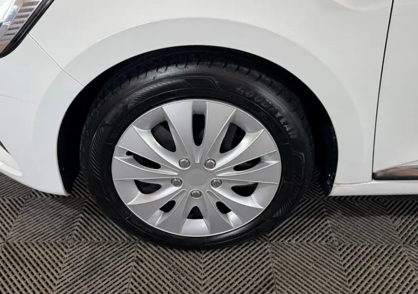 Gros plan sur la roue avant droite d'une Renault Clio Business TCe 100 blanche, avec jante en alliage argenté.