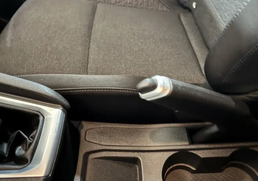 Gros plan sur le frein à main et la console centrale noire de la Renault Clio Business TCe 100 de 2020.