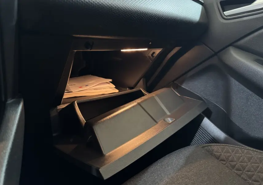 Vue intérieure côté passager de la boîte à gants ouverte de la Renault Clio Business TCe 100 blanche de 2020.