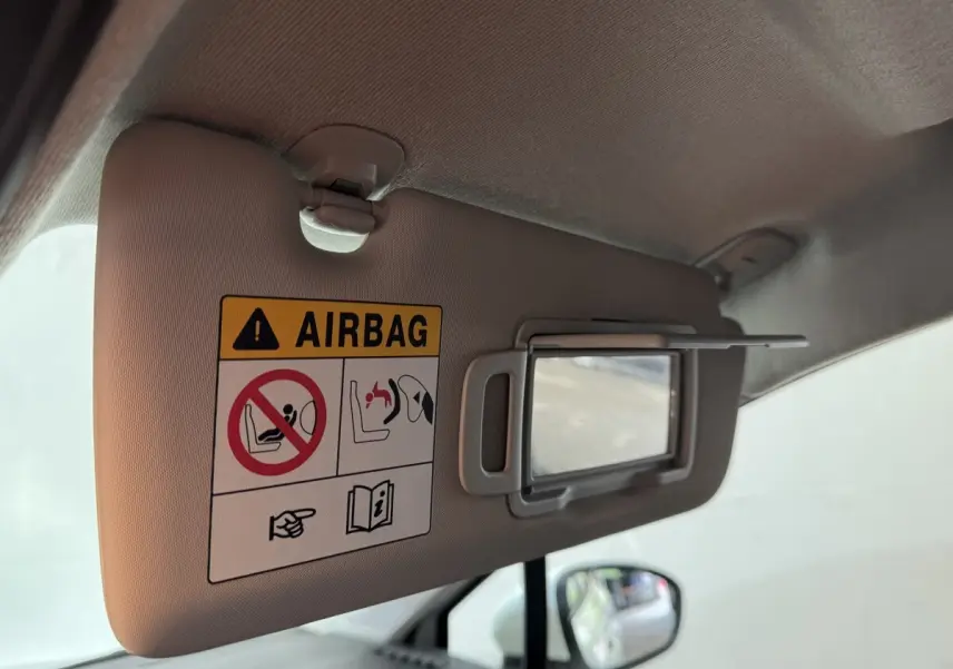 Vue intérieure du pare-soleil côté conducteur avec avertissement airbag dans une Renault Clio Business blanche de 2020.