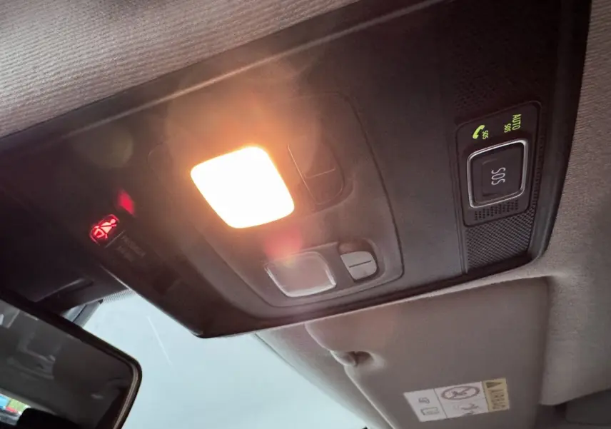 Plafonnier intérieur allumé avec bouton SOS et miroir de courtoisie dans une Renault Clio Business blanche.