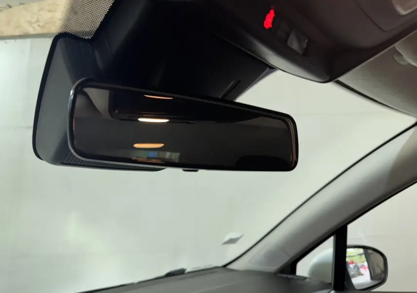 Vue intérieure du rétroviseur central d'une Renault Clio Business TCe 100 blanche, avec rétroviseur extérieur droit visible.