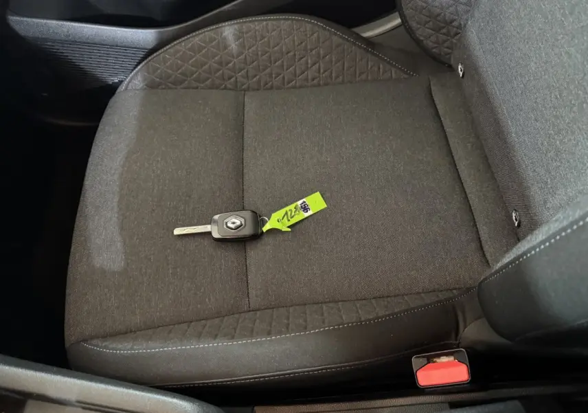 Vue rapprochée du siège avant droit gris foncé d'une Renault Clio avec clé de contact posée dessus.