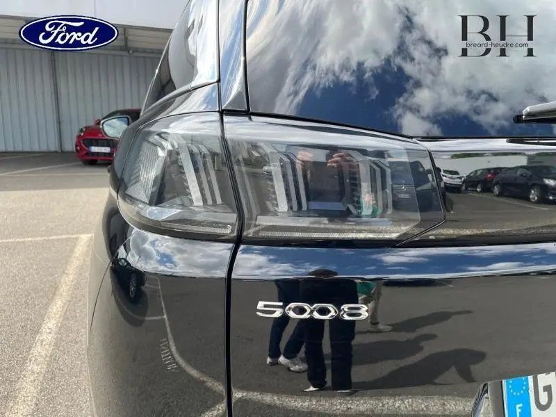 Gros plan sur le feu arrière droit noir Perla Nera d’un Peugeot 5008 2021 avec logo 5008 visible sur le hayon.