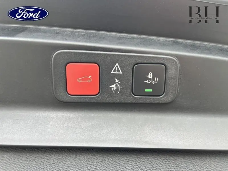 Gros plan sur les boutons de commande du hayon motorisé mains libres, sur fond intérieur noir.
