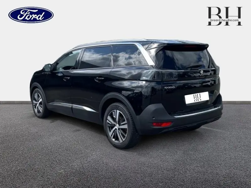Peugeot 5008 noir Perla Nera vue 3/4 arrière droit, hayon motorisé et jantes alliage visibles.