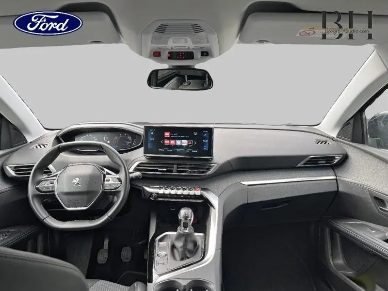 Vue intérieure avant du Peugeot 5008 noir Perla Nera, tableau de bord avec écran tactile et volant multifonction.